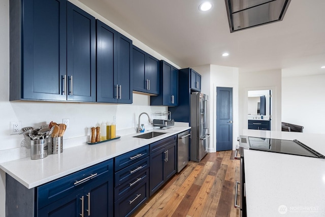 kitchen featuring blue cabinetry, stainless steel appliances, dark hardwood / wood-style floors, and sink