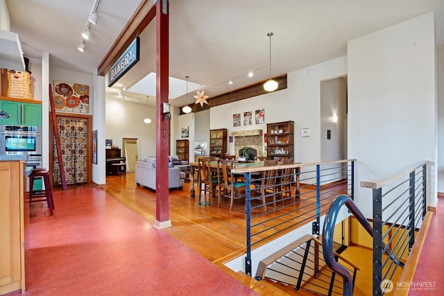 dining area with a fireplace, track lighting, and wood finished floors