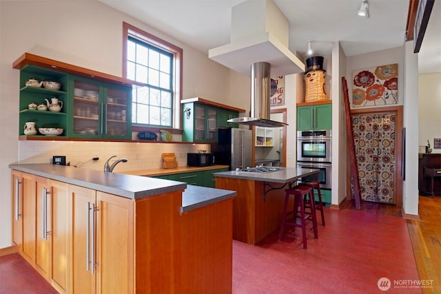 kitchen featuring a center island, a breakfast bar area, open shelves, dark countertops, and appliances with stainless steel finishes