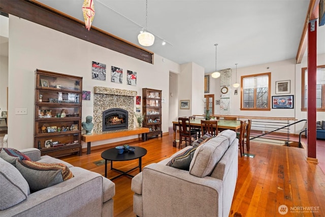 living area with a tile fireplace and wood finished floors