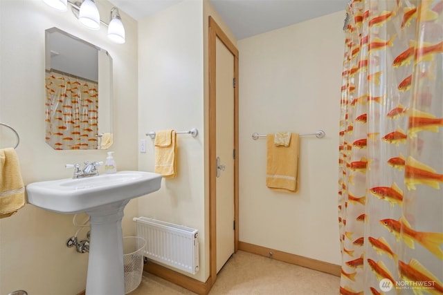 full bath featuring baseboards, a shower with shower curtain, and radiator