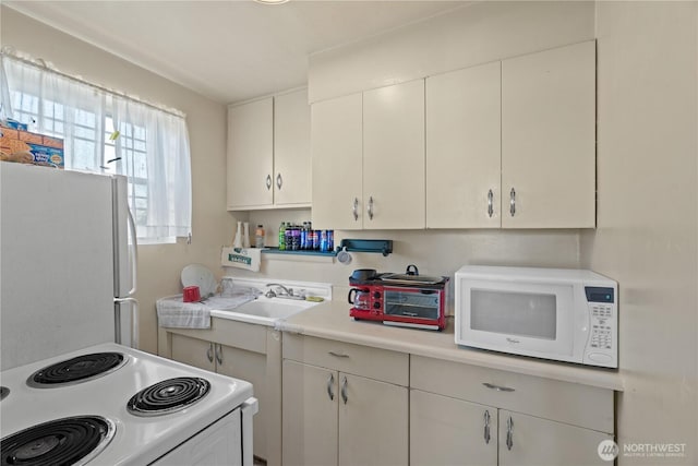 kitchen featuring sink, white appliances, and white cabinets