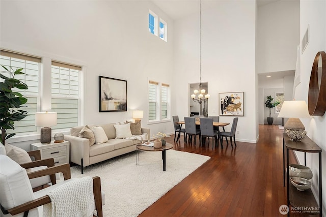 living room featuring dark wood-type flooring and a chandelier