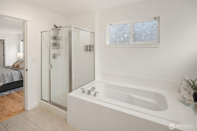 bathroom with separate shower and tub and tile patterned flooring