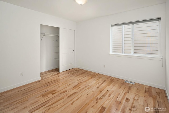 unfurnished bedroom featuring light hardwood / wood-style floors and a closet