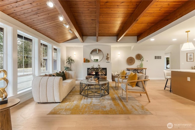 living area featuring visible vents, track lighting, light wood-type flooring, wooden ceiling, and a lit fireplace