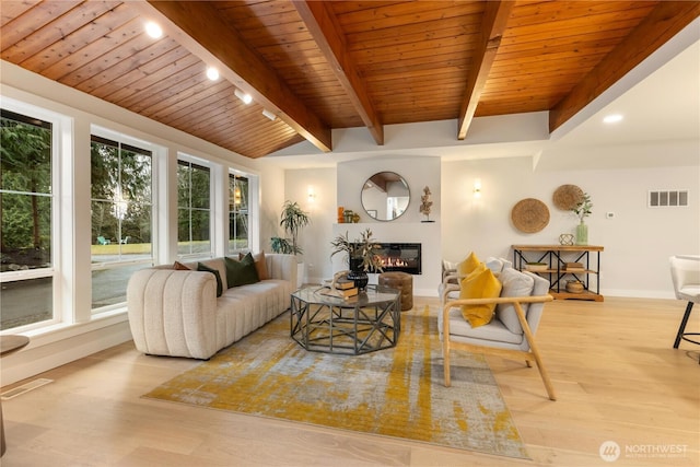 living room featuring visible vents, a glass covered fireplace, light wood-type flooring, wooden ceiling, and baseboards