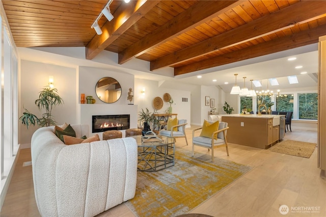 living area featuring wooden ceiling, recessed lighting, visible vents, light wood-type flooring, and a glass covered fireplace