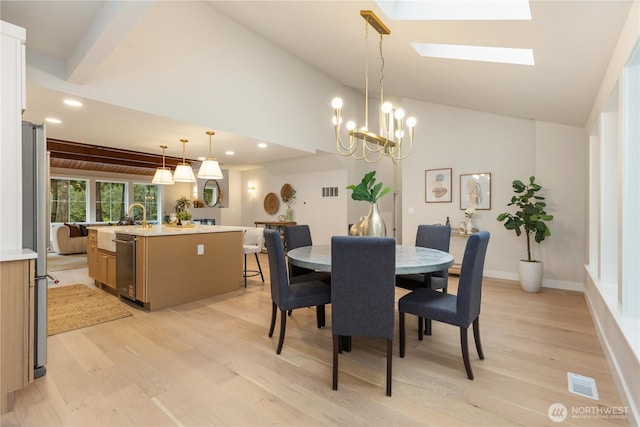 dining space with a skylight, recessed lighting, visible vents, light wood-style flooring, and high vaulted ceiling