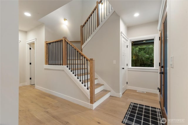 stairway with visible vents, baseboards, wood finished floors, and recessed lighting