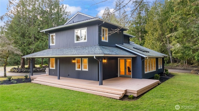 back of property featuring french doors, roof with shingles, a yard, and a wooden deck