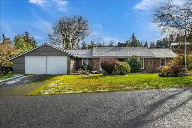 ranch-style house featuring a garage, brick siding, a chimney, aphalt driveway, and a front yard