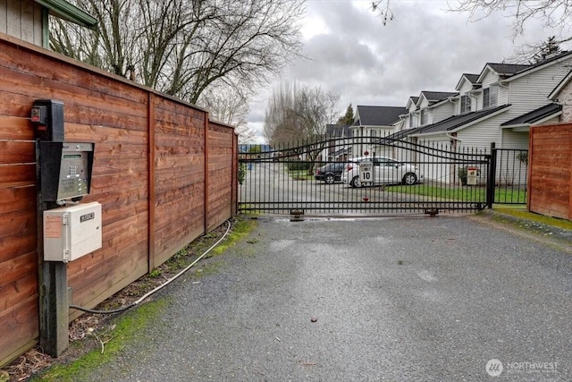 view of gate with fence and a residential view