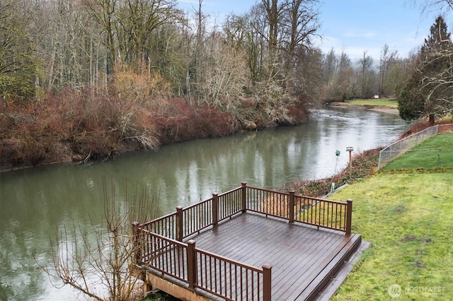 dock area featuring a lawn and a deck with water view