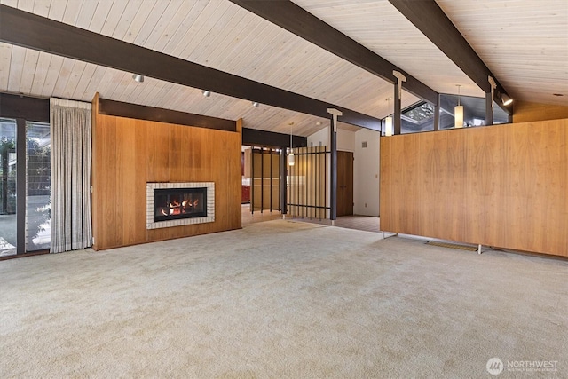 unfurnished living room with light carpet, wood walls, and vaulted ceiling with beams