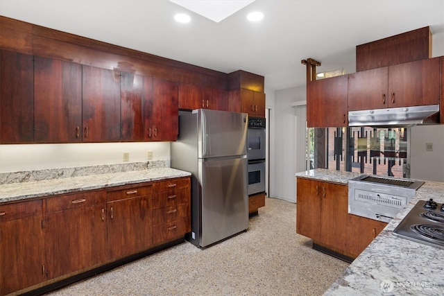 kitchen with under cabinet range hood, appliances with stainless steel finishes, light stone counters, and recessed lighting