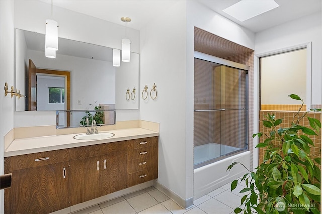 full bath featuring a skylight, baseboards, enclosed tub / shower combo, tile patterned flooring, and vanity