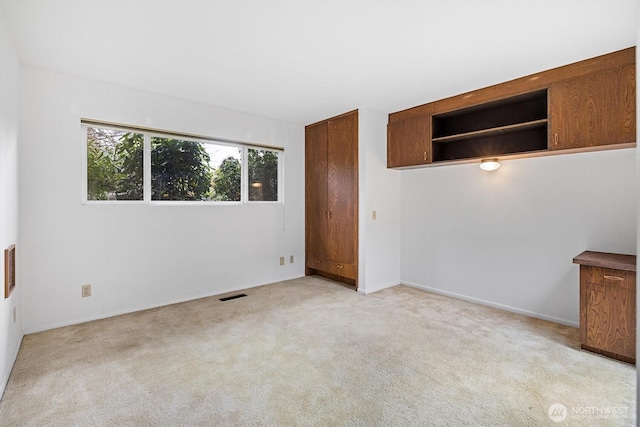 empty room with visible vents and light carpet