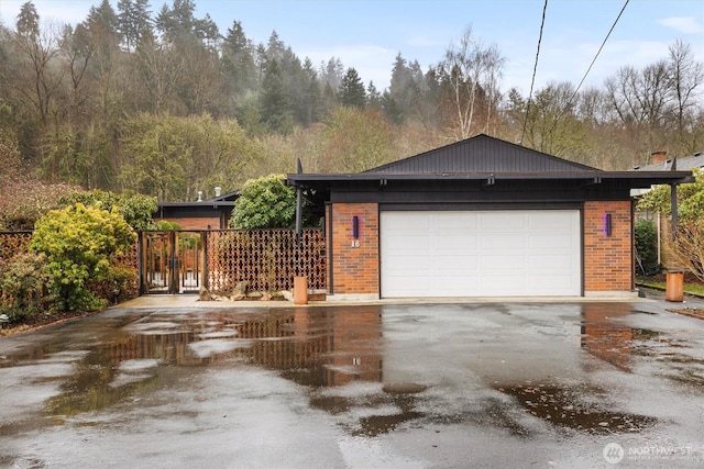 view of side of home featuring a garage and brick siding