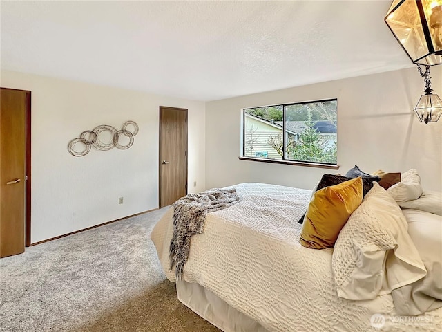 bedroom with carpet, a textured ceiling, and baseboards