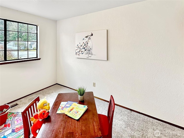 carpeted dining area featuring baseboards