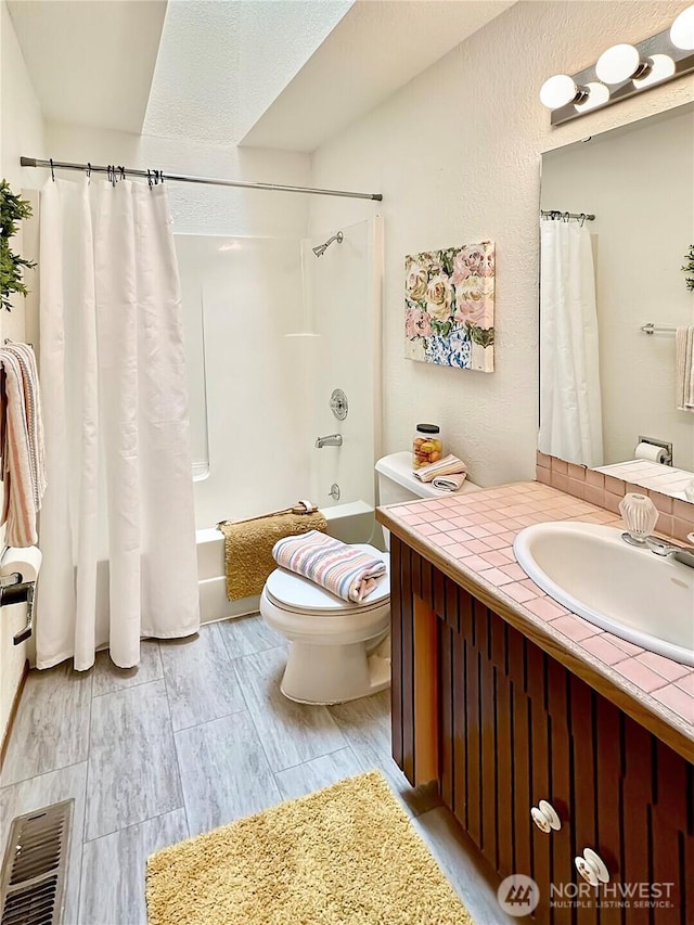 full bath with toilet, shower / tub combo, visible vents, and vanity