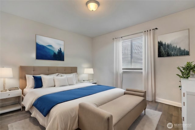 bedroom with wood finished floors and baseboards