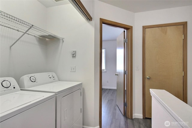 laundry room with baseboards, dark wood-type flooring, independent washer and dryer, and laundry area