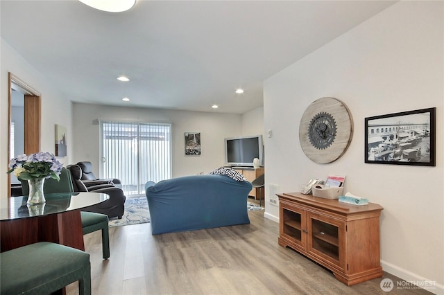 living room with recessed lighting, baseboards, and light wood-style flooring