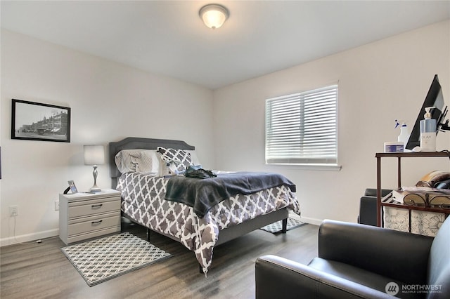 bedroom featuring baseboards and wood finished floors