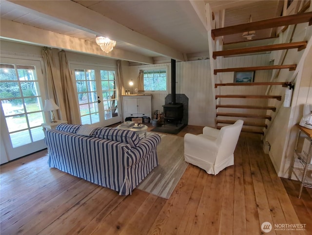 living room featuring french doors, a wealth of natural light, beamed ceiling, and light hardwood / wood-style floors