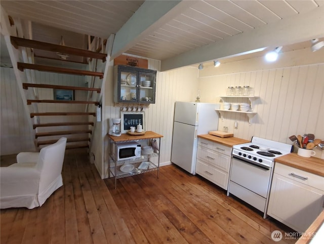 kitchen featuring white appliances, butcher block counters, beamed ceiling, dark hardwood / wood-style floors, and white cabinets