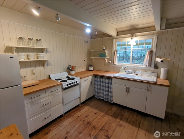 kitchen featuring white electric stove, white cabinets, stainless steel fridge, and wood counters