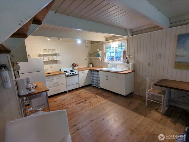 kitchen with beam ceiling, white appliances, butcher block countertops, white cabinets, and light hardwood / wood-style floors