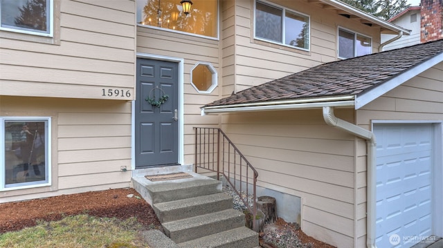 view of exterior entry with a shingled roof