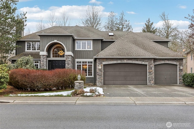 view of front of home featuring a garage, driveway, a shingled roof, and stone siding