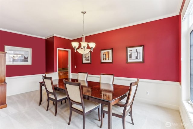 dining area with light carpet, a chandelier, and crown molding