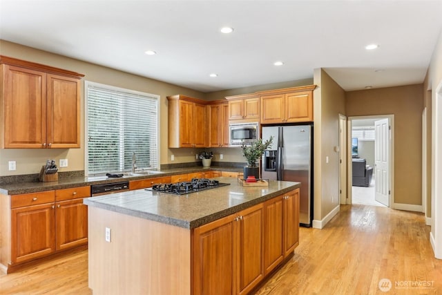 kitchen with light wood-style flooring, recessed lighting, stainless steel appliances, a kitchen island, and baseboards