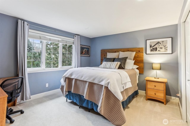 bedroom with baseboards and light colored carpet