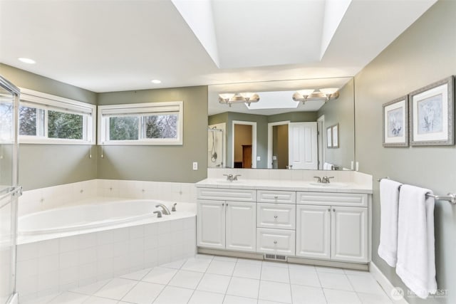 bathroom featuring tile patterned floors, a sink, a bath, and double vanity