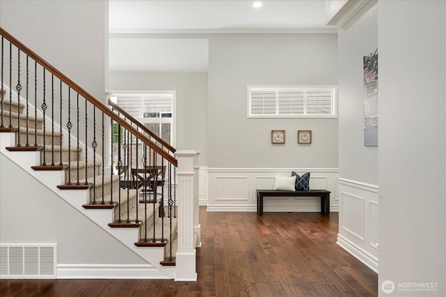 stairs featuring hardwood / wood-style floors and crown molding