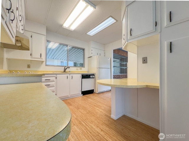 kitchen featuring light countertops, white appliances, light wood-type flooring, and white cabinets