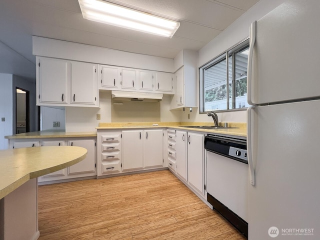 kitchen featuring white appliances, a sink, white cabinetry, light countertops, and light wood finished floors