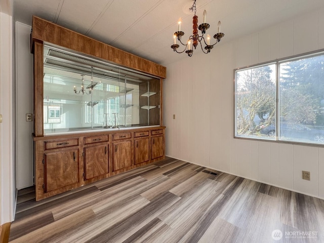 unfurnished dining area featuring visible vents and a chandelier