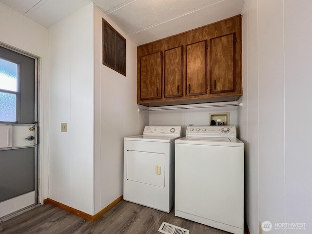 laundry area featuring cabinet space, visible vents, dark wood-type flooring, and washing machine and clothes dryer