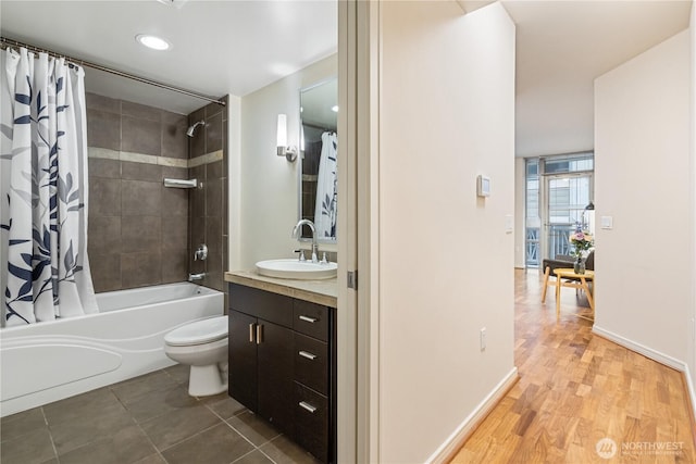 full bathroom with hardwood / wood-style flooring, vanity, shower / tub combo with curtain, and toilet