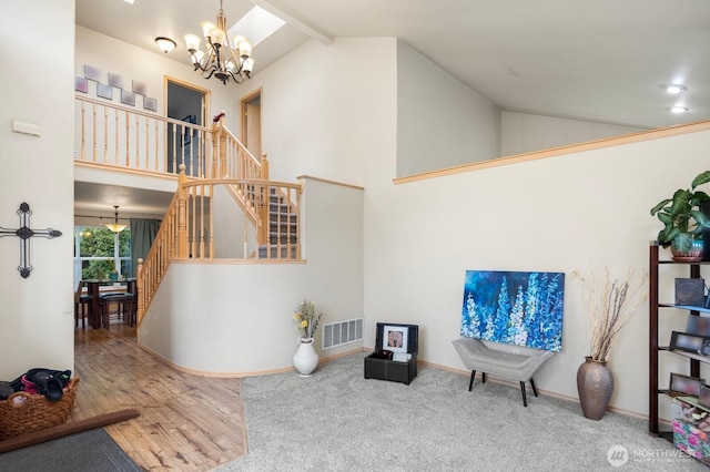 interior space featuring baseboards, visible vents, stairs, high vaulted ceiling, and a notable chandelier