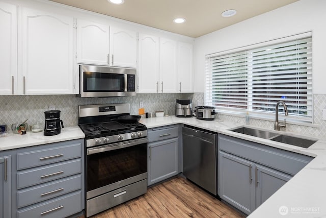 kitchen featuring a sink, white cabinetry, stainless steel appliances, and light countertops