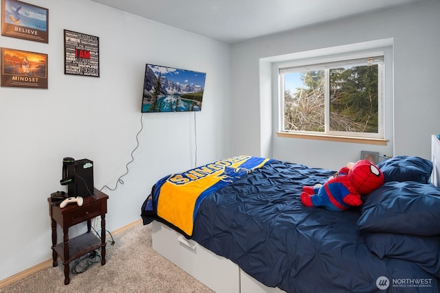 bedroom with baseboards and light colored carpet