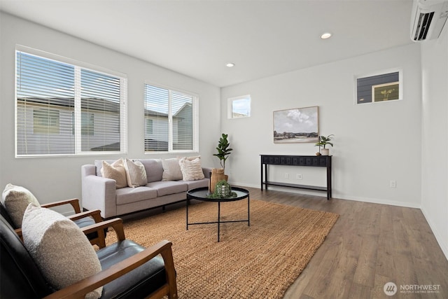 living area featuring recessed lighting, baseboards, wood finished floors, and a wall mounted AC